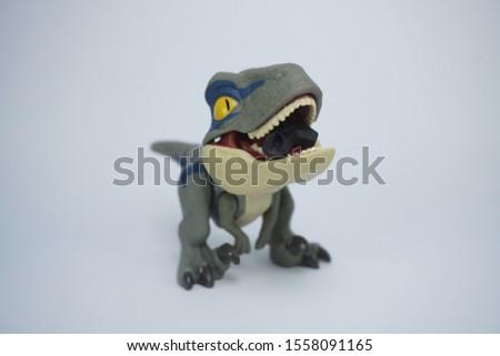 dinosaur toy opening it's mouth in white background 