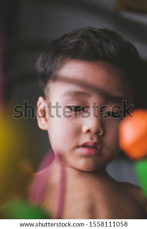 A young boy focusing playing with bead roller coaster toy without wearing any clothes. Selective Focus