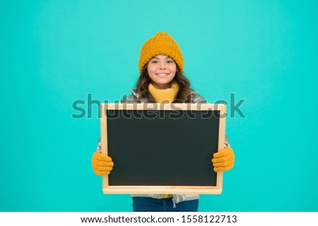 Winter entertainment and activities. Presentation concept. Smiling girl wear winter outfit blank chalkboard copy space. Fresh information. Information for children. Happy holidays. Show information.