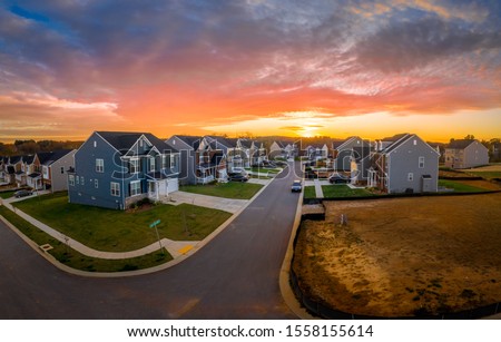 Aerial view of new construction cul-de-sac street with luxury houses in a Maryland upper middle class neighborhood American real estate development in the USA with stunning sunset orange color sky