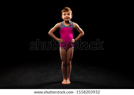 Young gymnast on a black background