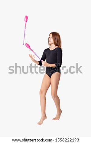 girl gymnast trains with a gymnastic clubs on white background. children's professional sports.