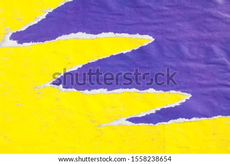 Yellow and purple old crumpled, torn and peeling paper placards texture background.