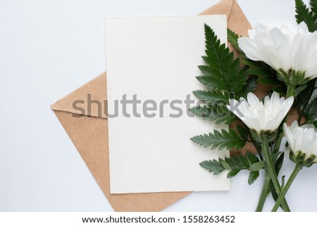 card mockup with chrysanthemums and envelope. wedding invitation in minimalist style with leaves
