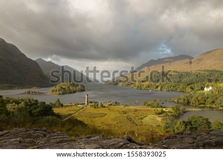 This is a picture from the Scottish Highlands on a cloudy day showing the Glenfinnan Monument on an eraly autumn morning.    