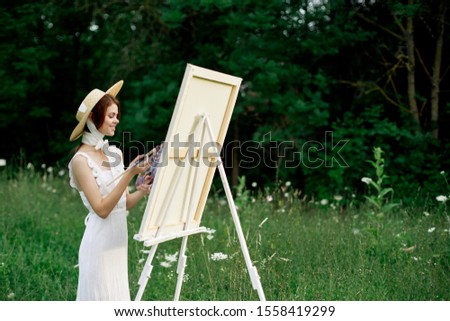young woman with red hair outdoors in a straw hat