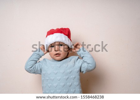 Funny little kid in red hat Santa. Christmas concept. Dancing happily.