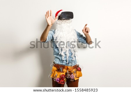 Santa Claus wearing virtual reality goggles, on a white background. Christmas