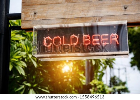 lluminated letters "Cold beer". Street sign