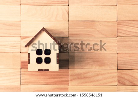 toy wooden house on wooden background, space for text, mock up