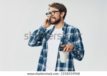 A man in a plaid shirt communicating by phone providing the services of an Internet manager