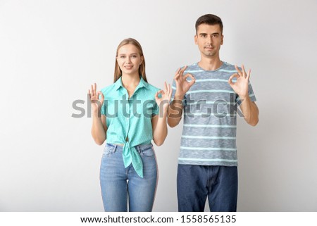 Young deaf mute couple using sign language on white background