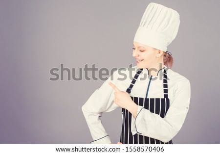 Choose items from a la carte menu. Pretty female cook pointing finger away and offering menu. Advertising for your restaurant menu. Menu list, copy space.