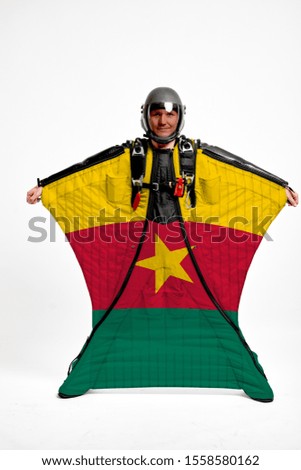 Cameroon flag travel. Bird Men in wing suit flag. Sky diving men in parashute. Patriotism, men and flag.
                              
