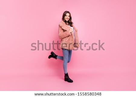 Full length profile photo of amazing millennial model lady standing confidently wearing stylish youth fluffy autumn jacket jeans shoes isolated pink background