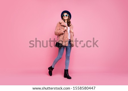 Full length photo of amazing millennial lady going down street watching sightseeing wear stylish jacket jeans shoulder bag sun specs hat isolated pink background
