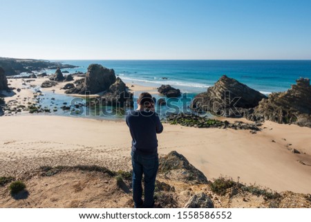 Man taking a photo of a beach in Costa Vicentina, Portugal