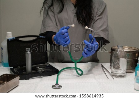 Doctor holds a phonendoscope in a surgical room