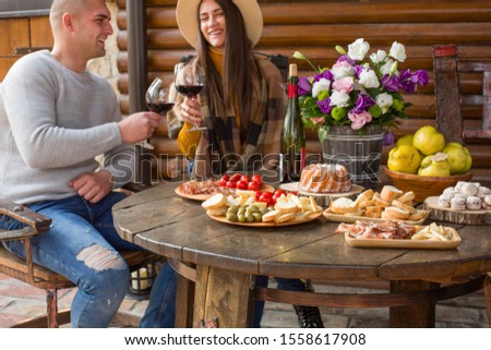 Happy Couple Toasting Glasses on a Autumn lunch
Lovely couple drinking wine  in rustic ambient.couple drinking wine during date 