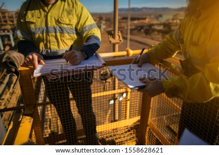 Safety workplace construction miner workers are signing of approvals high risk working at heights permit to work on the opening field prior starting early day shift 