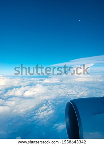 Sunrise above clouds from airplane window. Bright blue sky top horizontal view copyspace. Travelling concept View of the engine. 