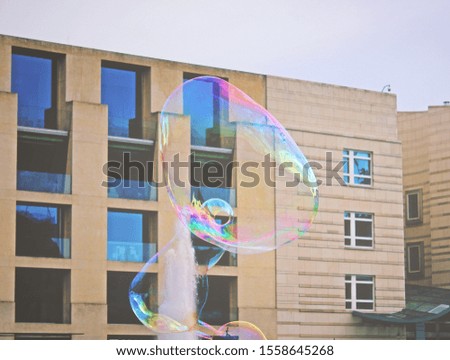 Soap bubbles in the city in front of a building in Berlin.
Urban big transparent bubbles over a socialistic building.