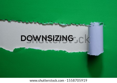Downsizing Text written in torn paper Royalty-Free Stock Photo #1558705919