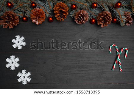 Merry Christmas and Happy Holidays greeting card, frame, banner. New Year. Noel. Silver, white and red Christmas ornaments and fir tree on black background top view. Winter holiday xmas theme.