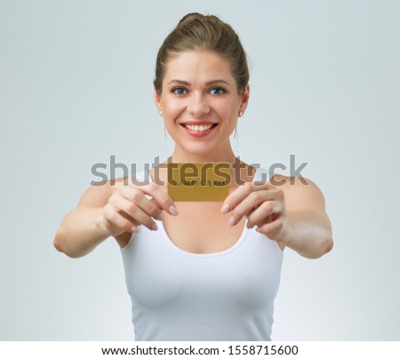 Smiling woman in white strap vest holding credit card in front of.  female portrait.