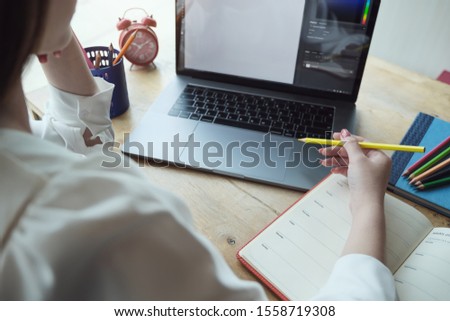Young women working with color pencil and notebook and computer laptop for using design or creative  to drawing Draw clothes design. freelance at work concept.