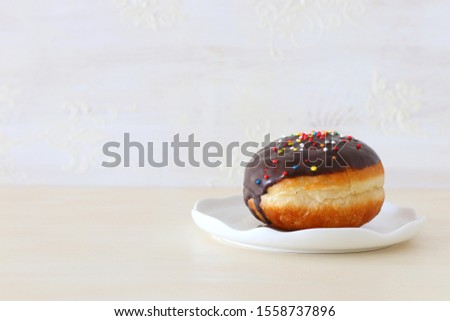 Image of jewish holiday Hanukkah with traditional doughnut on the table