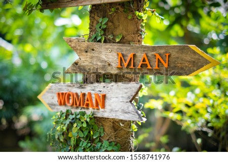 The left-right arrow wood sign with the words "man" and "woman" in English