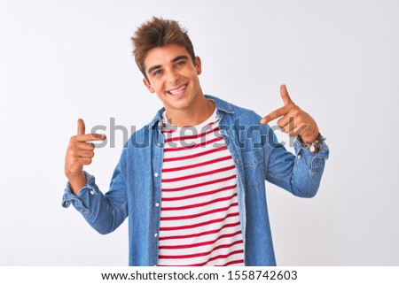 Young handsome man wearing striped t-shirt and denim shirt over isolated white background looking confident with smile on face, pointing oneself with fingers proud and happy.