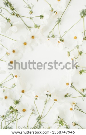 Minimal styled concept. Wreath made of white daisy chamomile flowers on white background. Creative lifestyle, summer, spring concept. Copy space, flat lay, top view.
