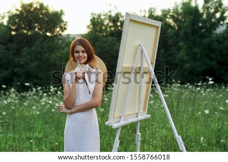 woman model on the street an easel paints on canvas