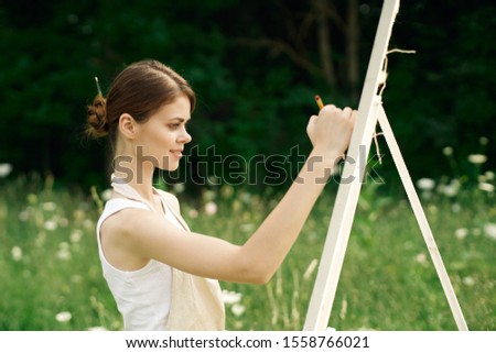 woman model on the street an easel paints on canvas