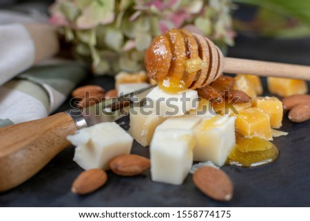 Delicious cheese mix with honey on black board. 