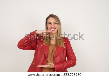 Young beautiful blonde woman over isolated background gesturing with hands showing big and large size sign, measure symbol. Smiling looking at the camera. Measuring concept.