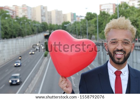 
Hip Afro-Caribbean businessman holding heart balloon 