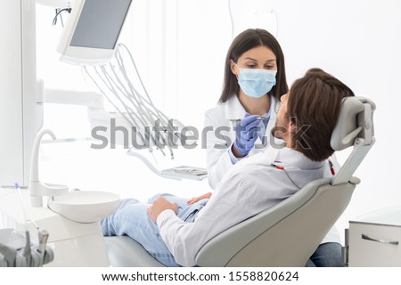 High service, care concept. Dentist woman making check up for patient in modern dental office, empty space Royalty-Free Stock Photo #1558820624