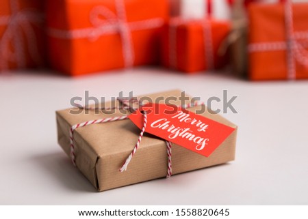 Small Christmas present with tag on blurred background, copy space