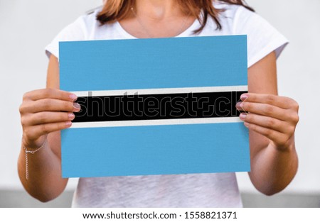 woman holds flag of Botswana on paper sheet
