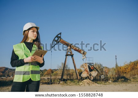Portrait of Professional Female Engineer Wearing Safety Uniform and Hard Hat. Engineer Woman Work on Digital Tablet.