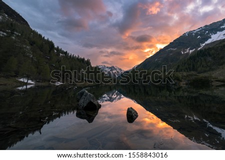 This picture was taken in Austria, portraining the breathtaking landscape and showing a mountain lake in spring during sunset.