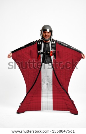 Latvia flag travel. Bird Men in wing suit flag. Sky diving men in parashute. Patriotism, men and flag.
                              