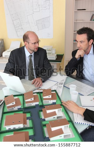 Architects gathered around a desk exchanging ideas