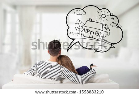 Young Thoughtful Couple Sitting On Sofa Thinking Of Getting Their Own House Royalty-Free Stock Photo #1558883210