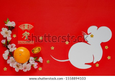 Chinese new year festival decoration on red background that cut in rat shape put on white paper. Chinese language on ingot means “Blessing”, on money red packet means “Great wishing”.