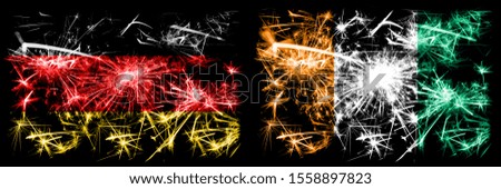 Germany, German vs Ivory Coast New Year celebration travel sparkling fireworks flags concept background. Combination of two abstract states flags.
