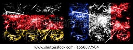 Germany, German vs France, French New Year celebration travel sparkling fireworks flags concept background. Combination of two abstract states flags.
